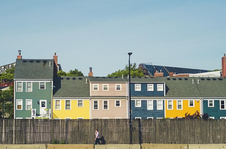 A row of painted wooden houses in green, yellow and blue